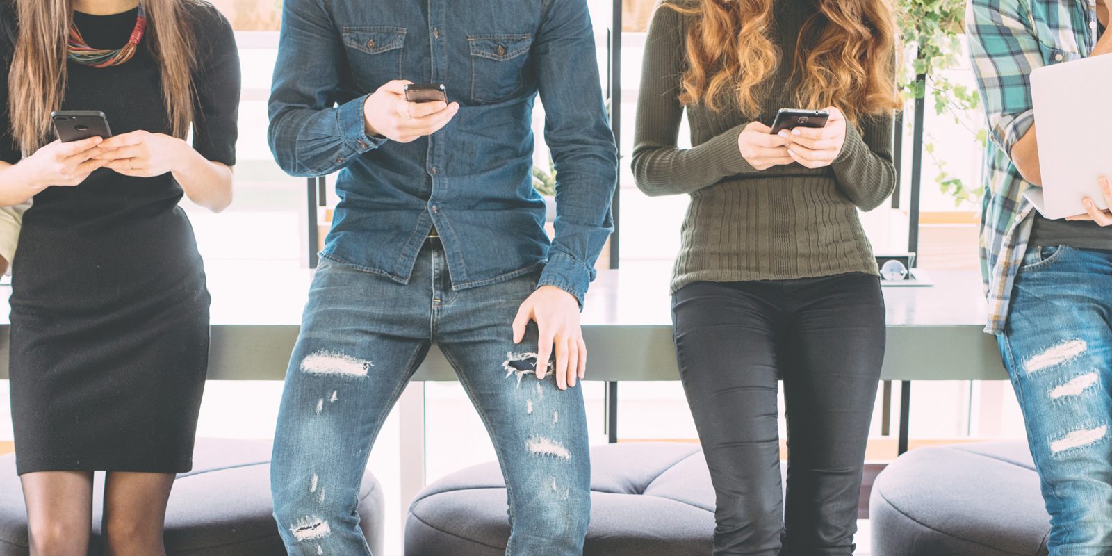 Junge Leute mit Smartphone auf Bank